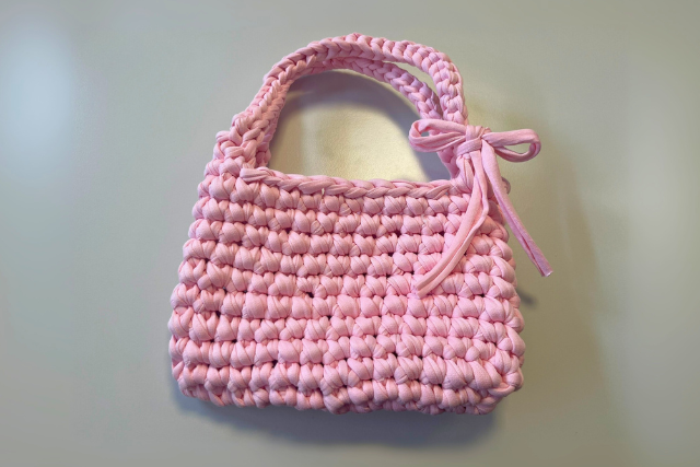Die vollständig gehäkelte Häkeltasche ist ausgelegt und komplett sichtbar.