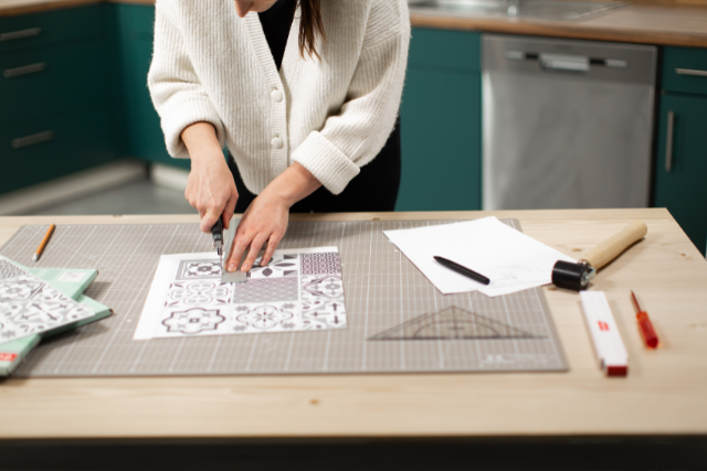 Die Wandfliesen werden mit Cutter zugeschnitten