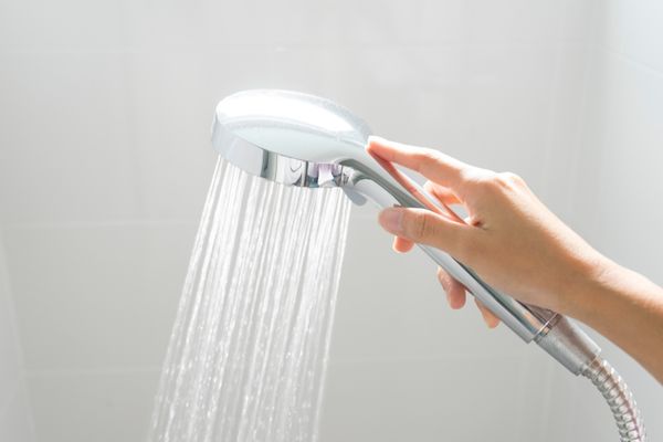 Entkalkter Duschkopf, aus dem Wasser fließt